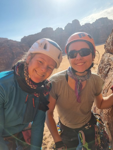 To damer med godt humør på standplass midt i ørkenen.